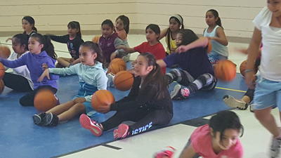 Coach instructing young basketball players