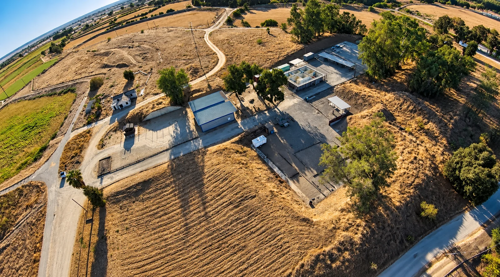 Aerial view of the Livingston Police Department shooting range, showing range areas, buildings, trees, and surrounding fields.